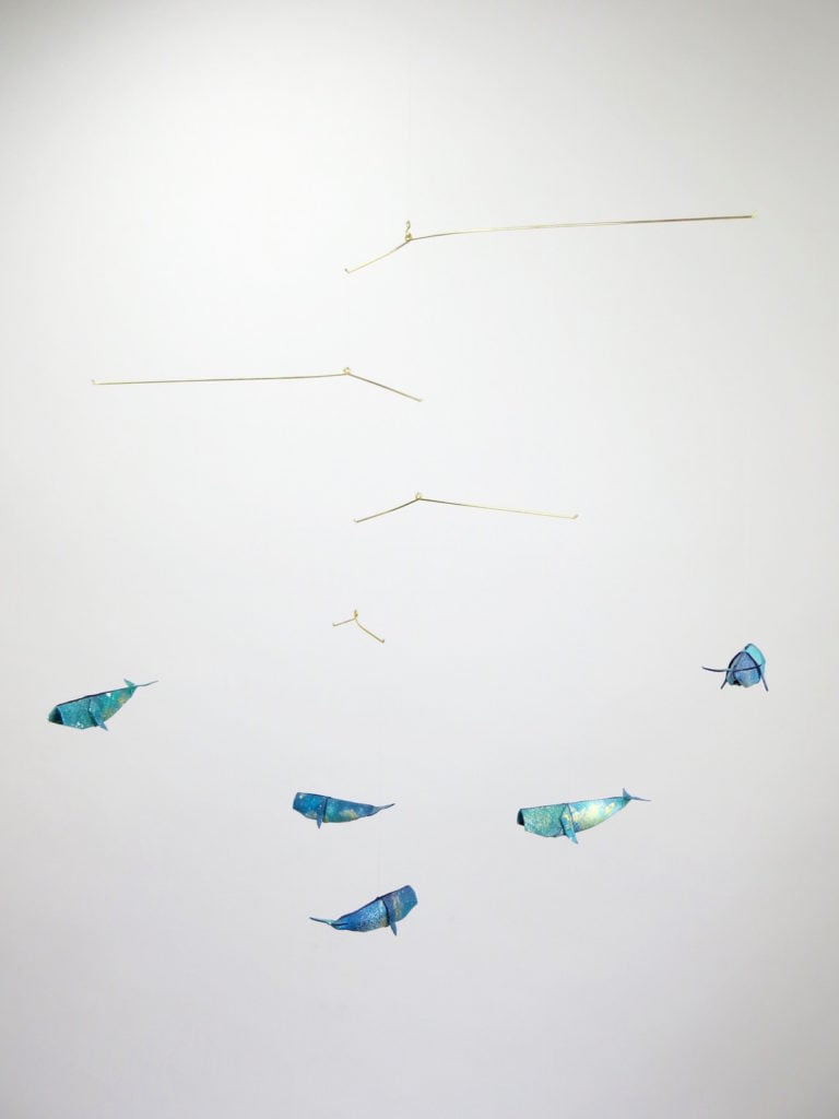 A hanging mobile with blue and golden whales