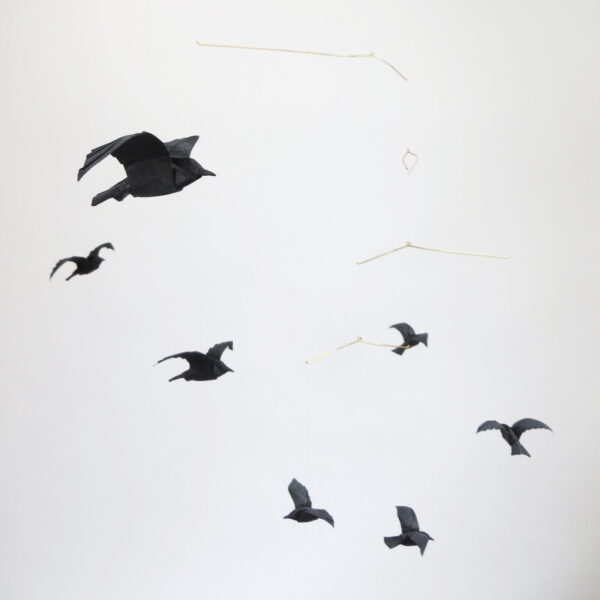 A hanging mobile with black origami crows or ravens