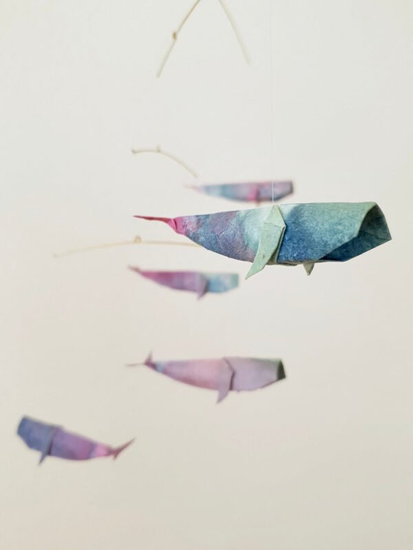 A hanging mobile with colorful origami whales