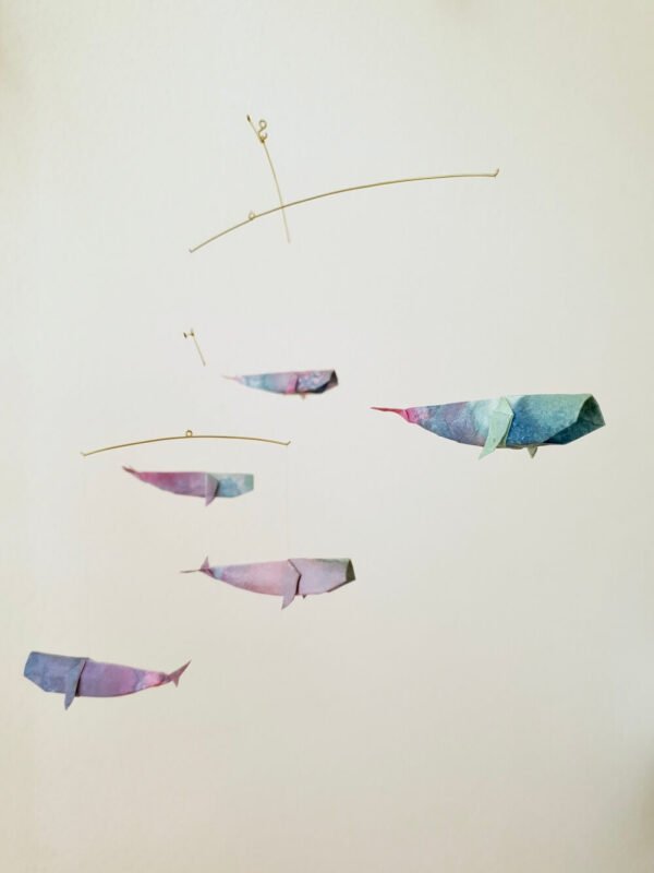 A hanging mobile with colorful origami whales