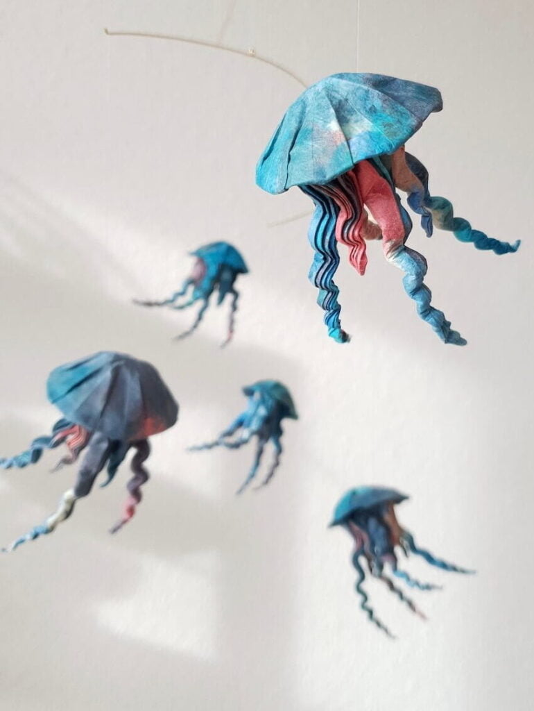 A hanging mobile with blue and red origami jellyfish