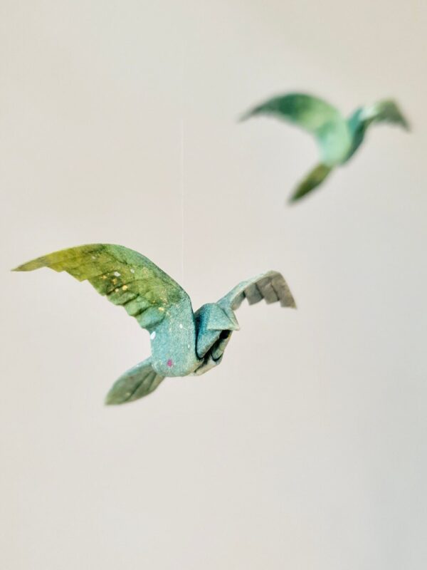 Two green origami birds folded from kozo washi