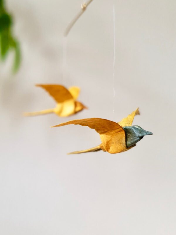 Two golden yellow origami birds