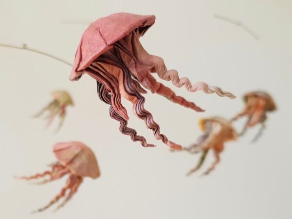 A hanging mobile with a red origami jellyfish