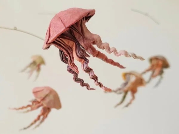 A hanging mobile with a red origami jellyfish