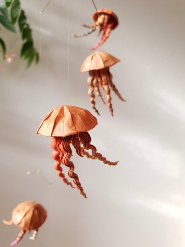 A hanging mobile with orange and brown jellyfish