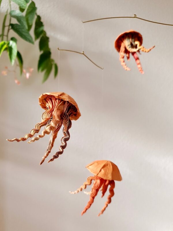 A hanging mobile with orange and brown jellyfish