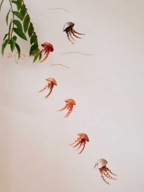 A hanging mobile with orange and brown jellyfish