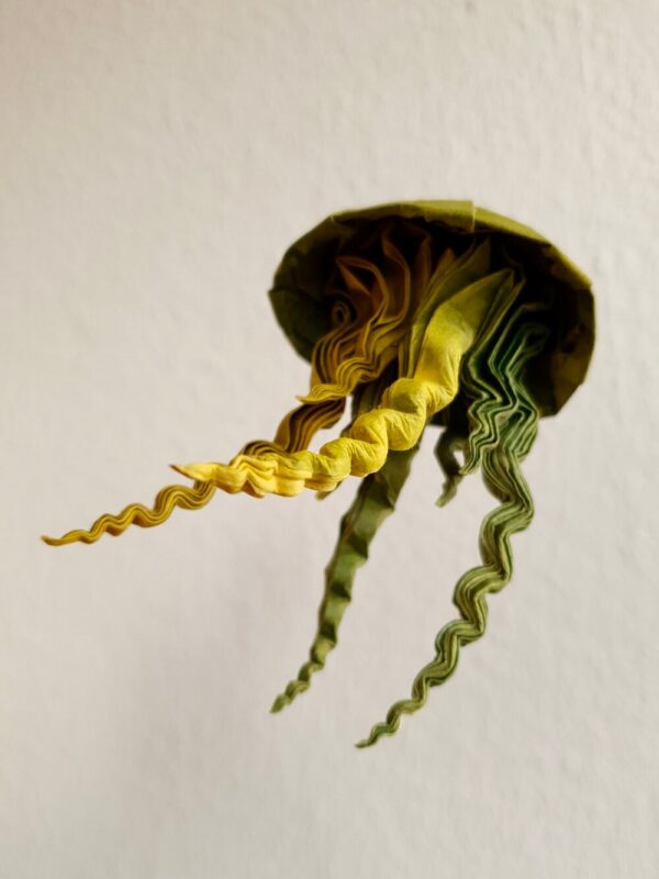 A green and yellow origami jellyfish