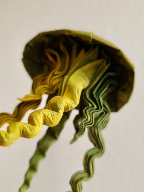 A green origami jellyfish in detail