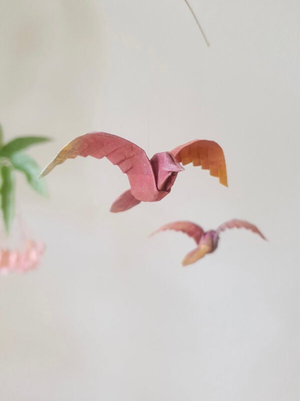 A hanging mobile with red origami birds