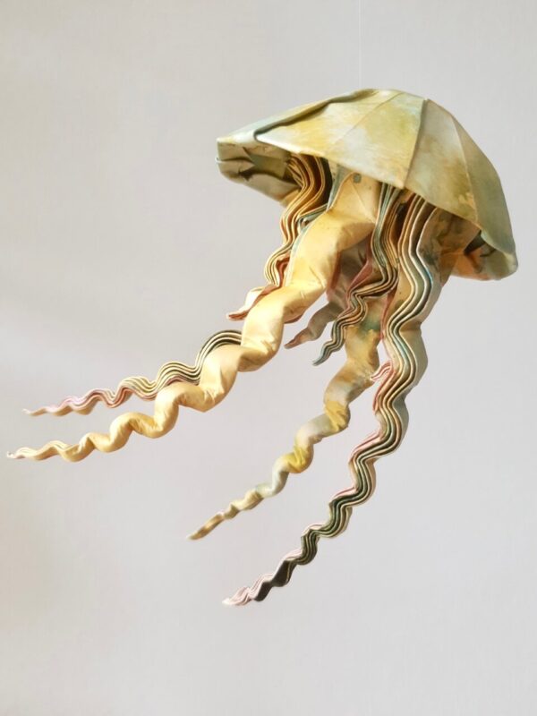 A green and yellow origami jellyfish