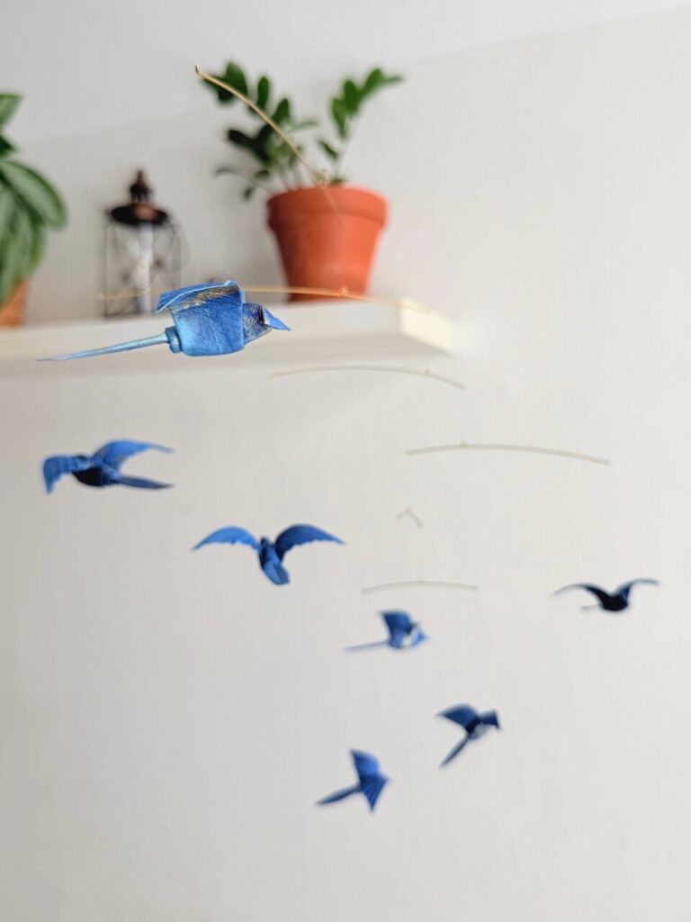 A hanging mobile with 7 blue origami birds