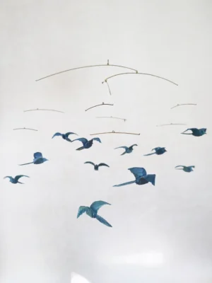 A large hanging mobile with 11 blue origami birds